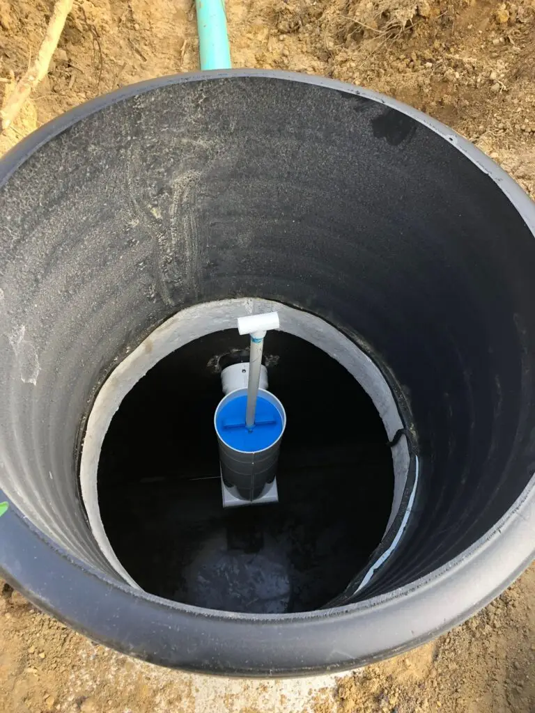 Interior view of a septic tank with an installed effluent filter and connected pipe, part of a residential septic system